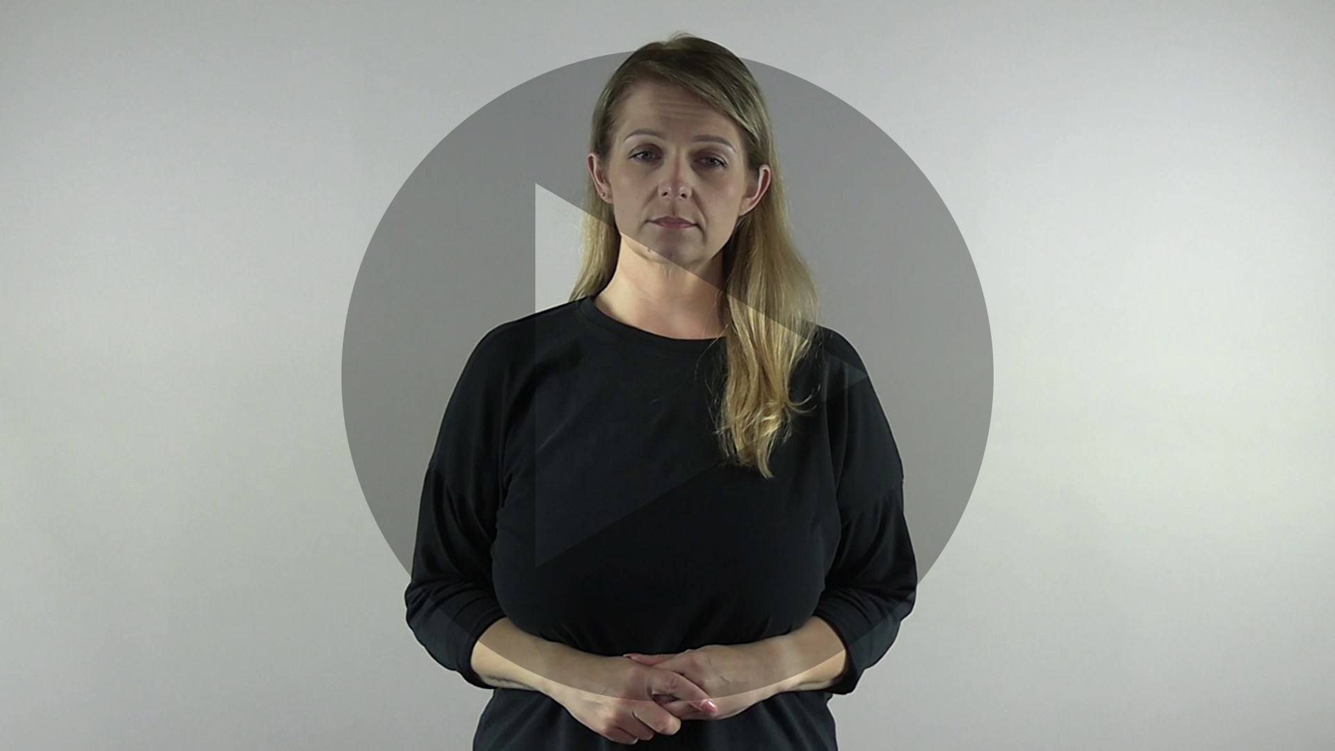 Kadr z nagrania przedstawiający tłumaczkę języka migowego. Na kadr naniesiony jest symbol odtwarzania wideo - trójkąt w kole