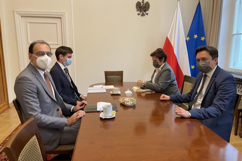 Trzech mężczyzn i kobieta siedzą przy stole