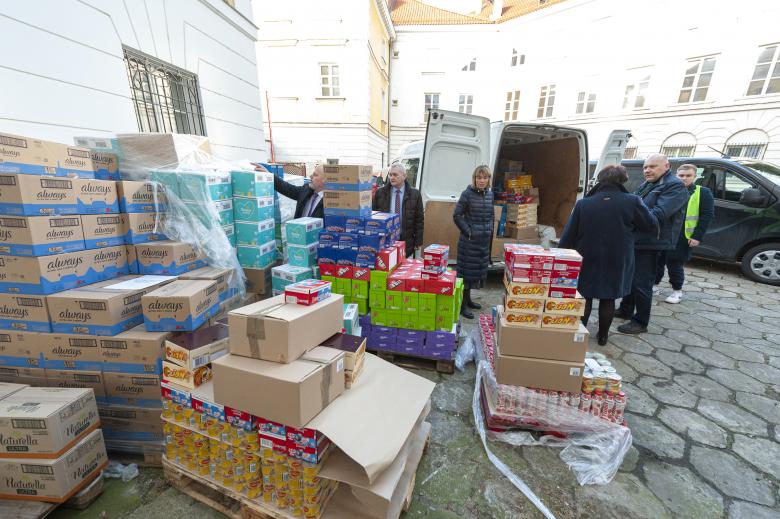 Palety z artykułami pierwszej potrzeby oraz pracownicy BRPO i wolontariusze ładujący artykuły do samochodu dostawczego