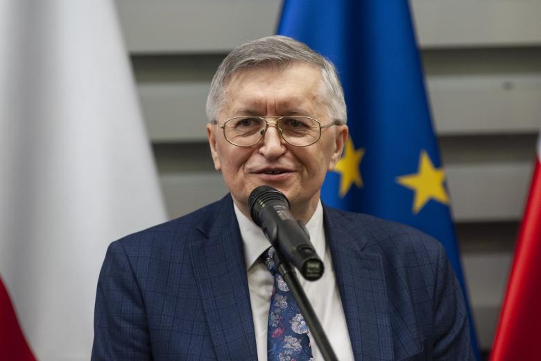 ZRPO Stanisław Trociuk przemawiający do mikrofonu na tle flag Polski i UE