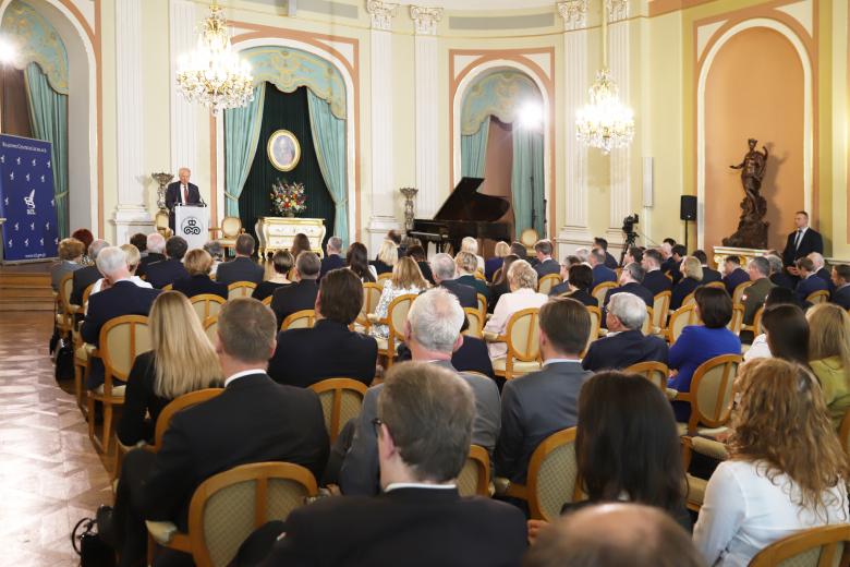 Goście konferencji słuchający wystąpienia jednego z prelegentów przemawiającego z mównicy