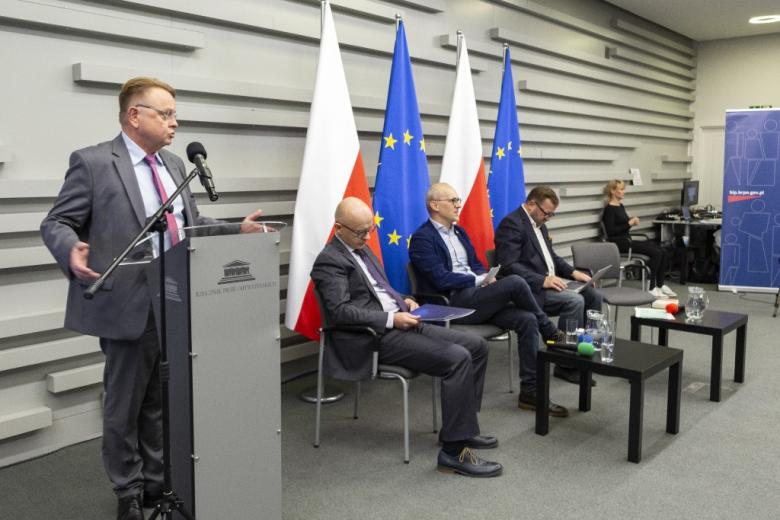 osoba przemawia podczas konferencji na stojąco 