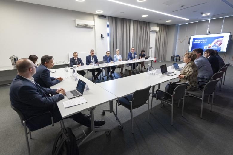 Grupa kilkunastu osób siedząca przy stole konferencyjnym