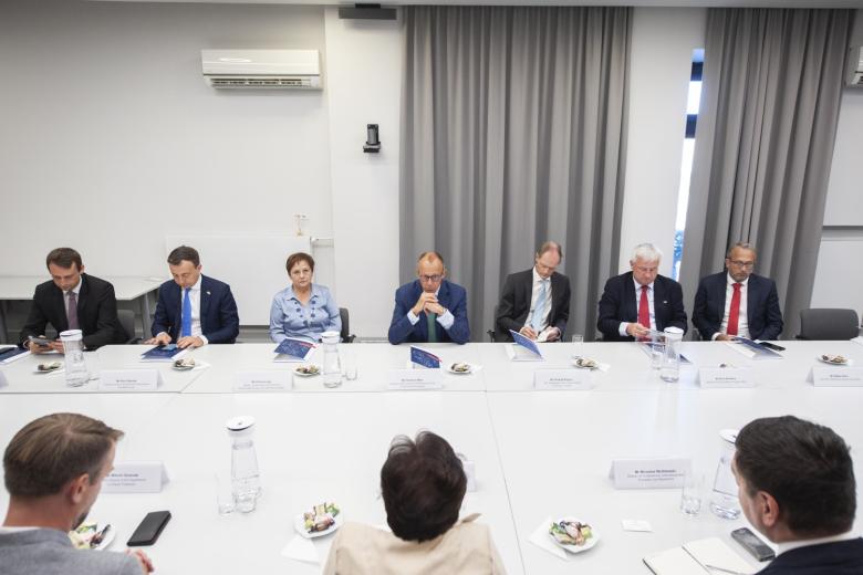 Siedem osób siedzących za stołem konferencyjnym