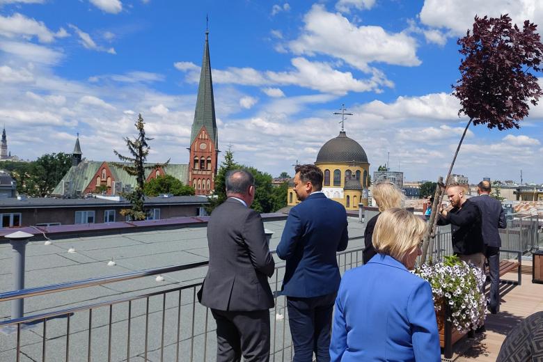 Ludzie stoją na tarasie - w tle krajobraz Częstochowy