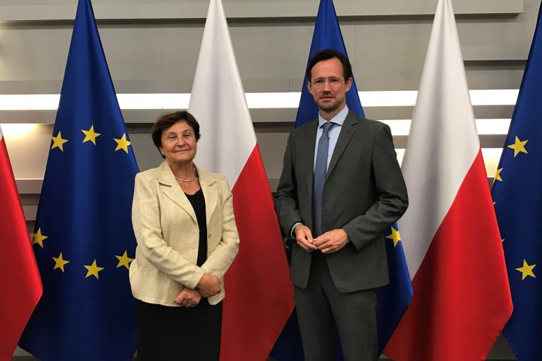 ZRPO Hanna Machińska pozująca z posłem na tle flag Polski i Unii Europejskiej