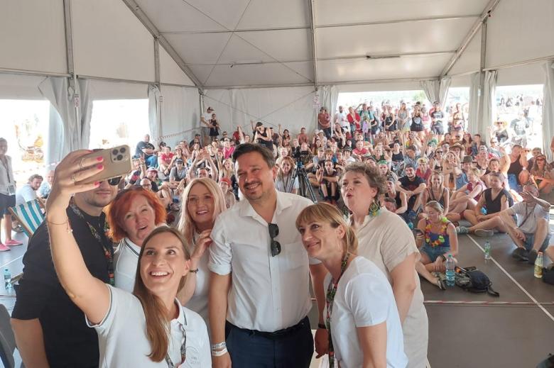 Osoby robią sobie selfie w namiocie pełnym innych ludzi 