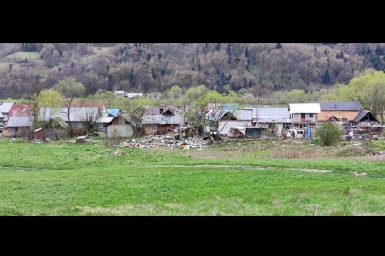 Niewielkie osiedle niszczejących budynków położone w dolinie między wzgórzami