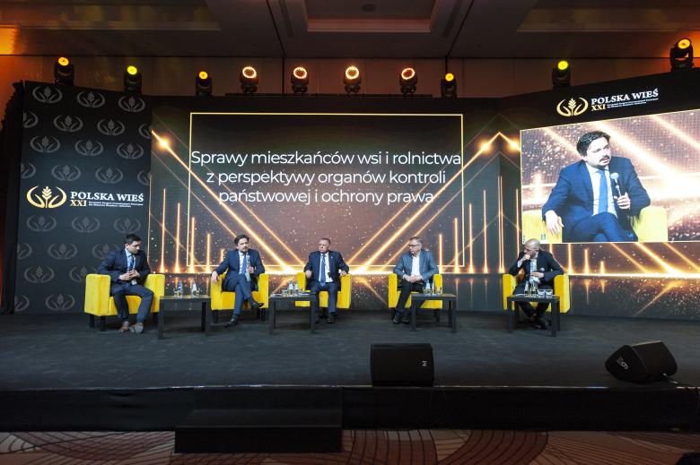 RPO oraz inni paneliści siedzą na scenie. Za nimi nazwa panelu "Sprawy mieszkańców wsi i rolnictwa z perspektywy organów kontroli państwowej i ochrony prawa".