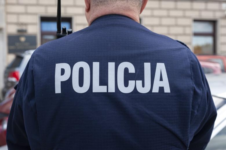 Policjant w mundurze z napisem POLICJA na plecach