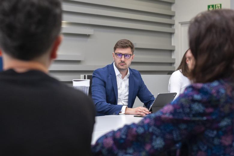 ZRPO Valeri Vachev słucha wypowiadających się w jego stronę osób, których plecy są widoczne na pierwszym planie.