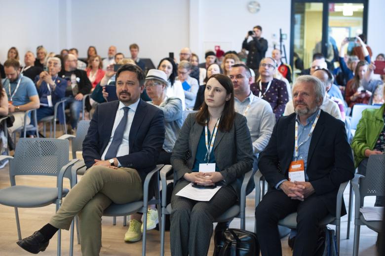 Kilkadziesiąt osób siedzi na sali konferencyjnej, na pierwszym planie RPO Marcin Wiącek, Monika Wiszyńska i Dariusz Supeł