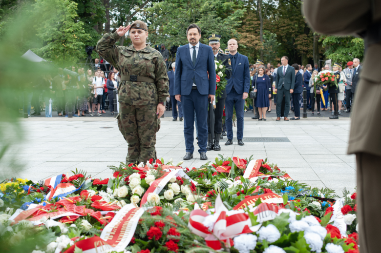 osoba składa wieniec pod pomnikiem 