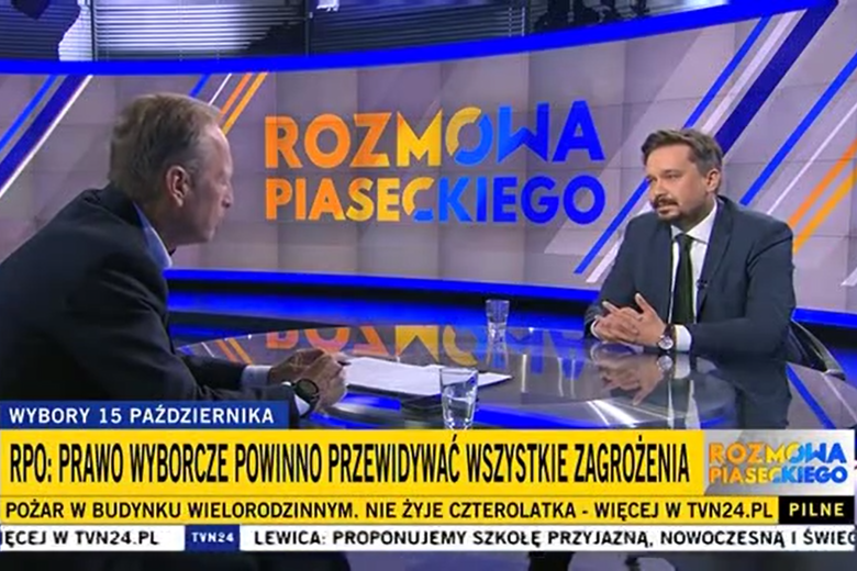 Zrzut ekranu programu telewizyjnego przedstawiający RPO Marcina Wiącka siedzącego w studiu