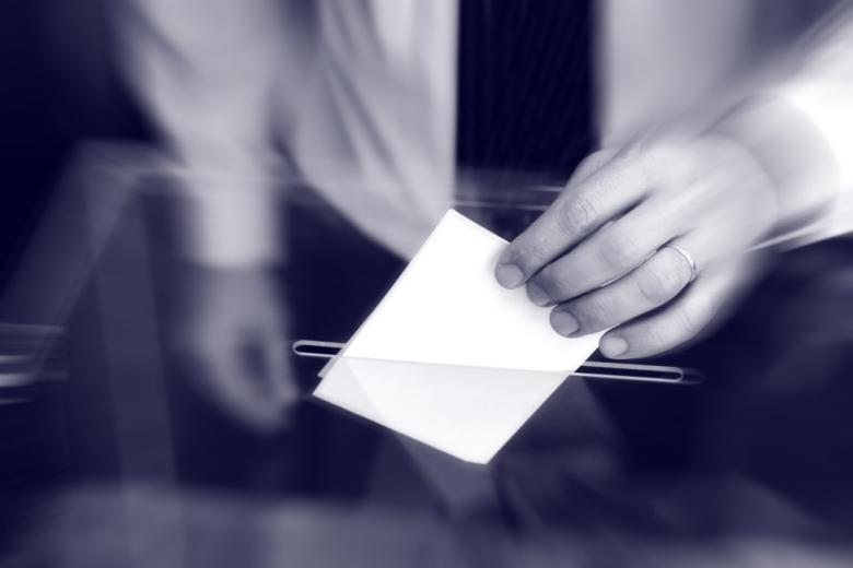 osoba wrzuca głosu do urny 