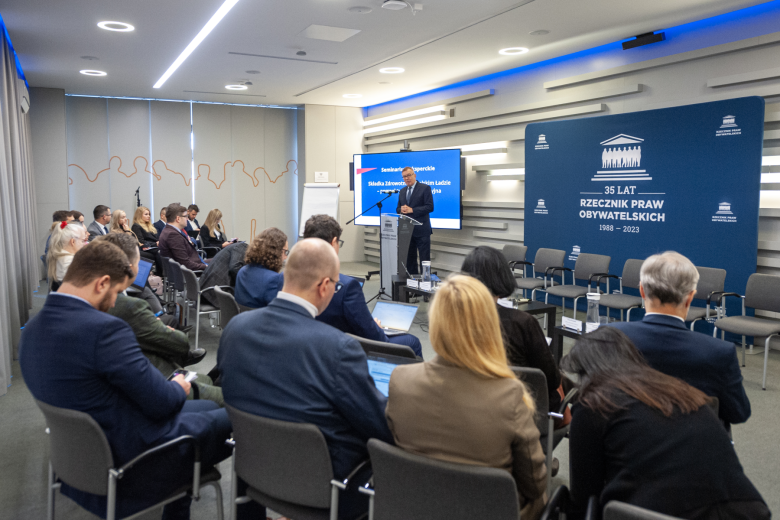 Kilkadziesiąt osób na sali konferencyjnej słucha wystąpienia