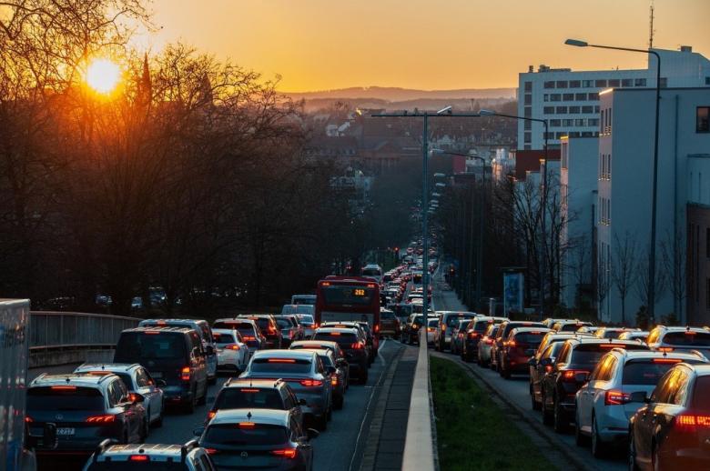 duży ruch uliczny w mieście na tle zachodzącego słońca 