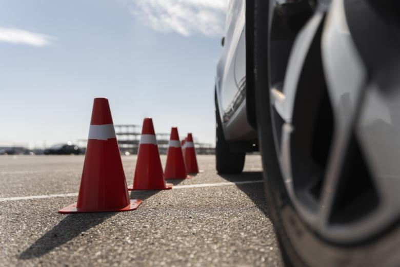 widok na koło samochodu i stojące obok stożki drogowe