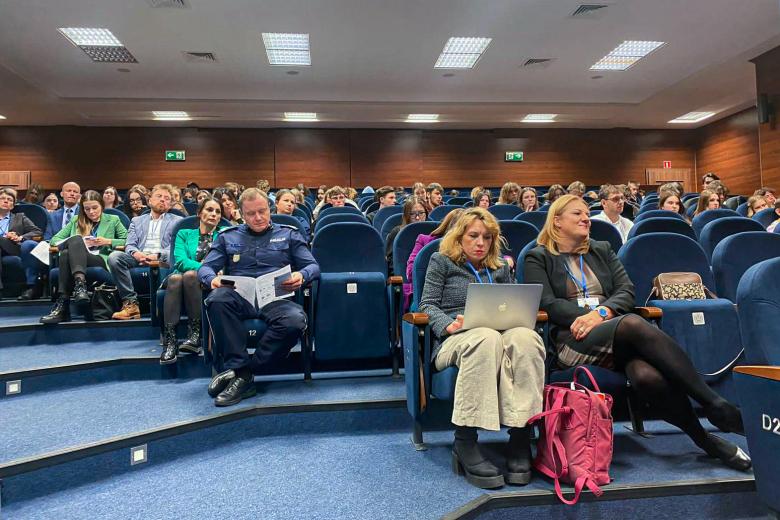 Kilkadziesiąt osób siedzących na auli wykładowej