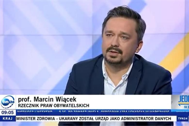 Zrzut ekranu programu telewizyjnego przedstawiający RPO Marcina Wiącka siedzącego w studiu