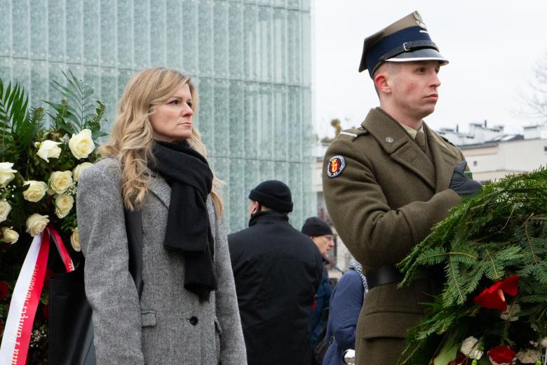 Anna Grzelak stoi w korowodzie razem z żołnierzem trzymającym wieniec