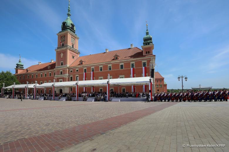 Widok ogólny rozstawionej na placu trybuny dla gości obchodów. Za trybuną jest Zamek Królewski