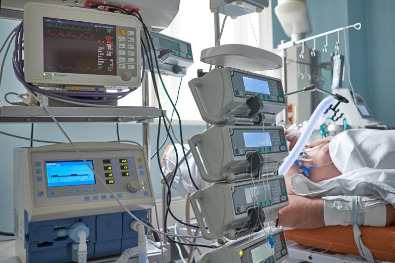 Aparatura medyczna stojąca obok łóżka z pacjentem na oddziale intensywnej terapii