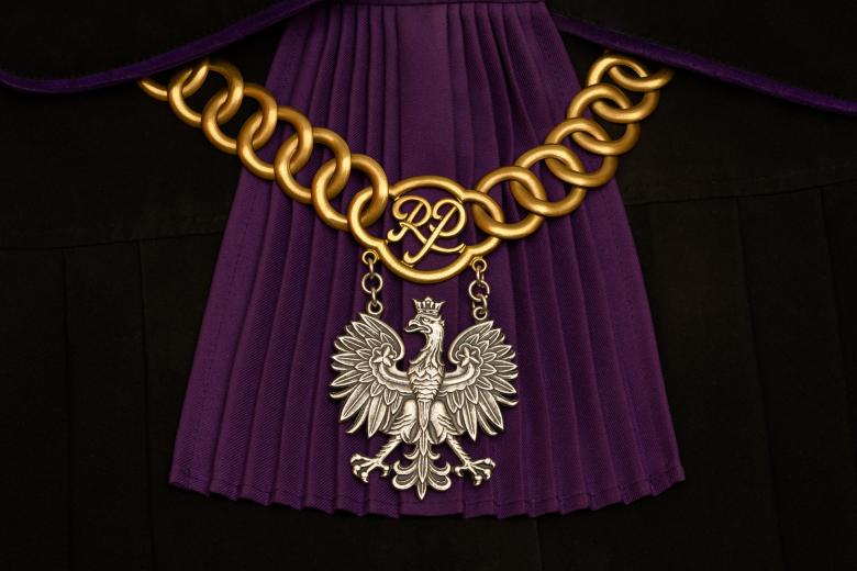 Łańcuch sędziowski z orłem w koronie założony na togę z purpurowym żabotem