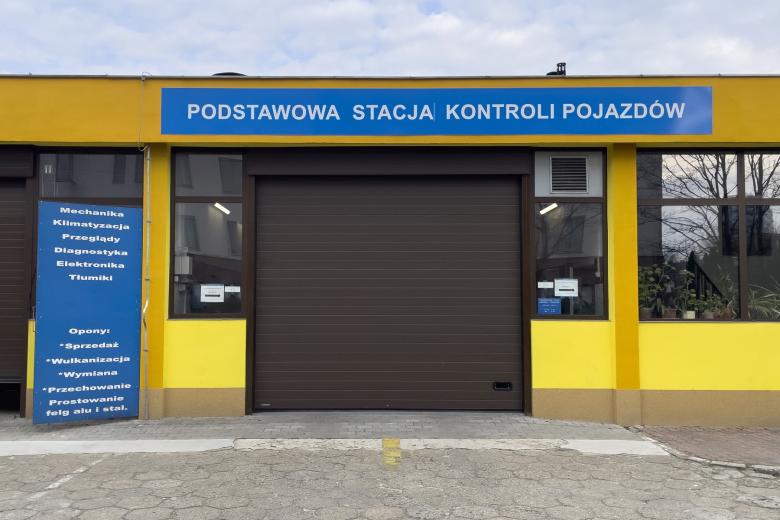 Budynek z zamkniętą bramą wjazdową i napisem "Podstawowa stacja kontroli pojazdów"