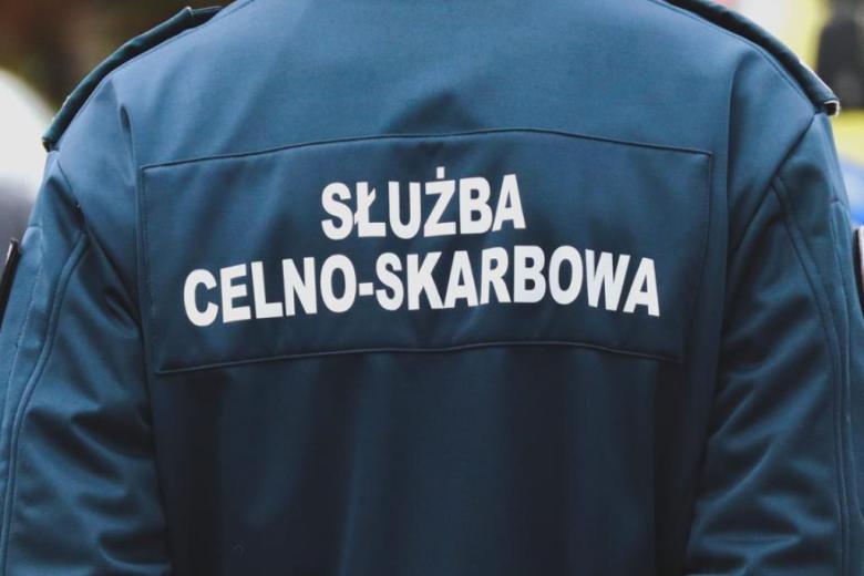 człowiek odwrócony tyłem w kurtce z napisem służba celno-skarbowa 