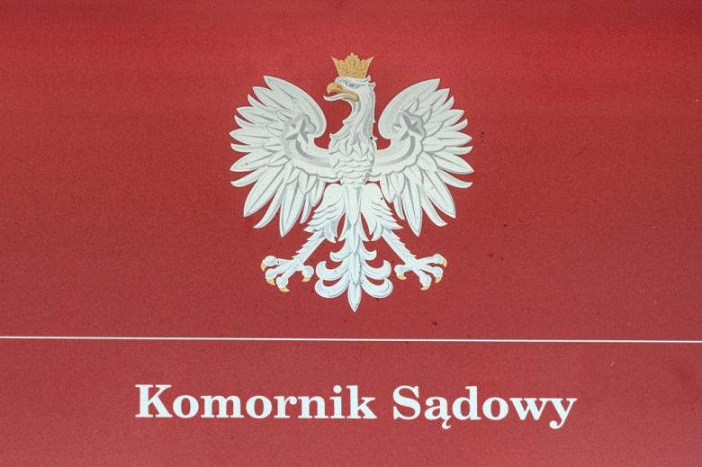 tablica z polskim godłem i napisem komornik sądowy