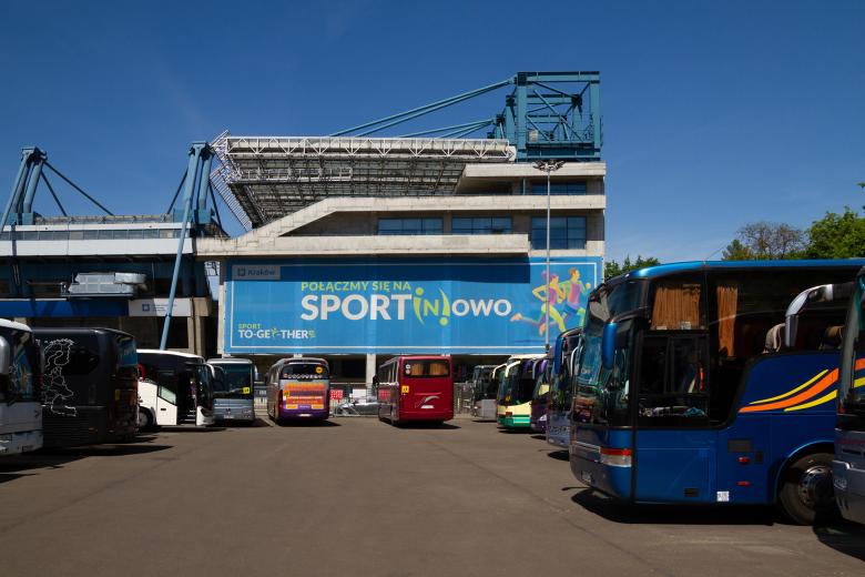 Parking przed Stadionem Miejskim w Krakowie, na którym stoją zaparkowane autokary