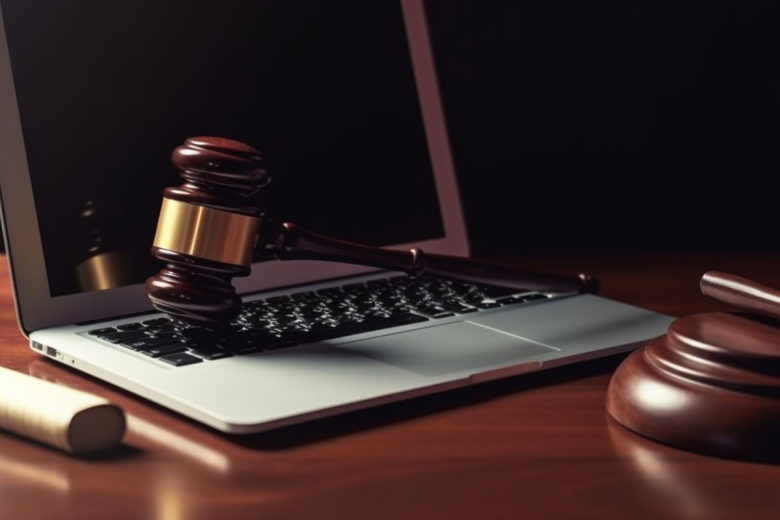 Młotek sędziowski leży na otwartym laptopie