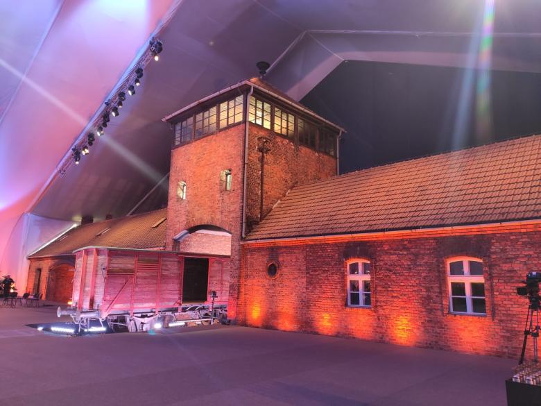 Brama kolejowa obozu Auschwitz przygotowana do obchodów 80. rocznicy wyzwolenia obozu - podświetlona i przykryta dużym namiotem 
