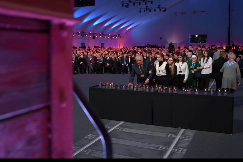 Uczestnicy obchodów składają znicze w namiocie, w którym odbywają się uroczystości. 