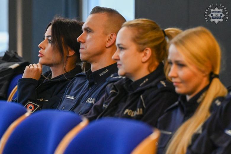 Policjanci w mundurach siedzą na sali wykładowej i słuchają wystąpienia