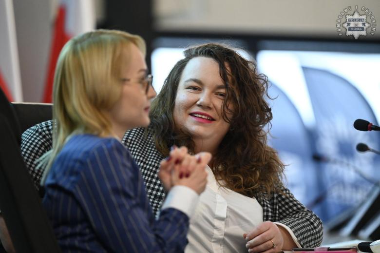 Dwie osoby siedzą na sali wykładowej i rozmawiają ze soną