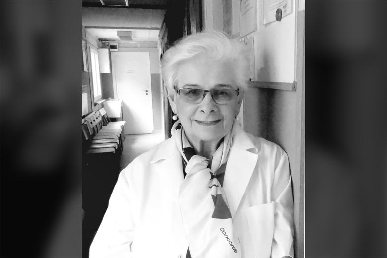 Portret dr. Moniki Madalińskiej - uśmiechnięta kobieta opierająca się o ścianę w korytarzu