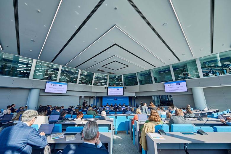 Duża sala konferencyjna, na której w ławach siedzą uczestnicy konferencji