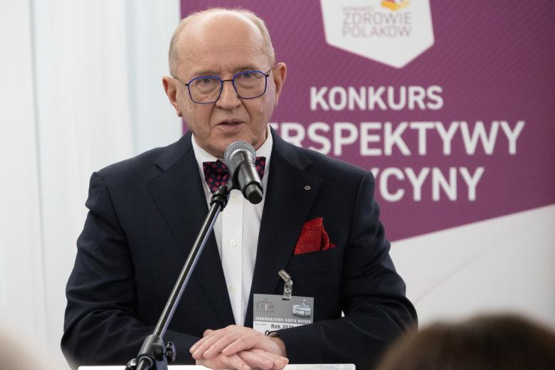 Henryk Skarżyński wypowiada się w stronę publiczności stojąc przy mikrofonie