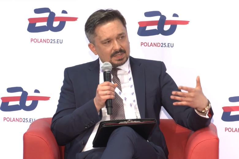 RPO Marcin Wiącek mówi do mikrofonu siedząc w fotelu podczas panelu na konferencji