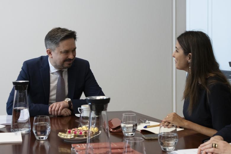 Marcin Wiącek i Teresa Anjinho rozmawiają siedząc przy stole konferencyjnym