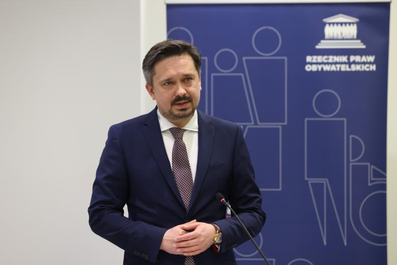 Marcin Wiącek wypowiada się stojąc przy mównicy