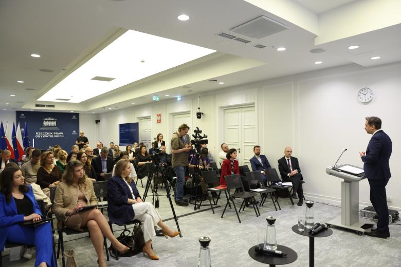 RPO Marcin Wiącek wypowiada się z mównicy w stronę widowni 