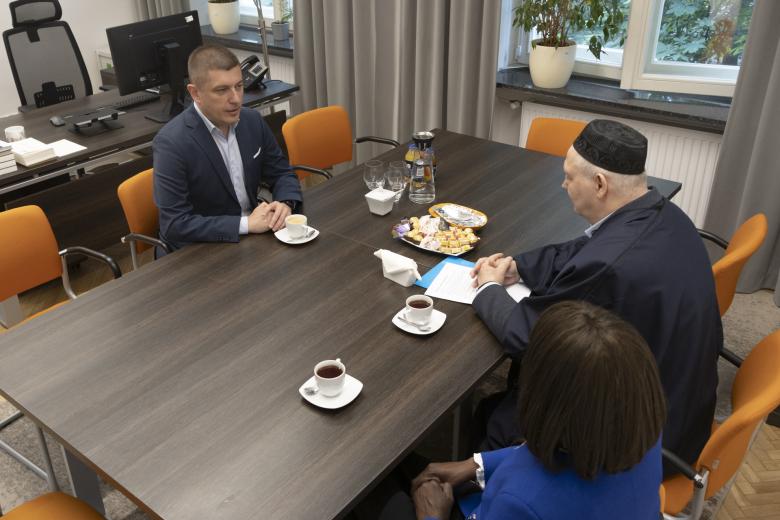 Trzy osoby siedzące przy stole