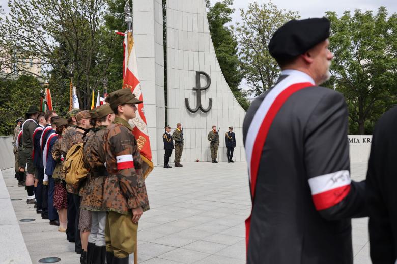 Widok na grupę osób pod Pomnikiem Armii Krajowej i Polskiego Państwa Podziemnego