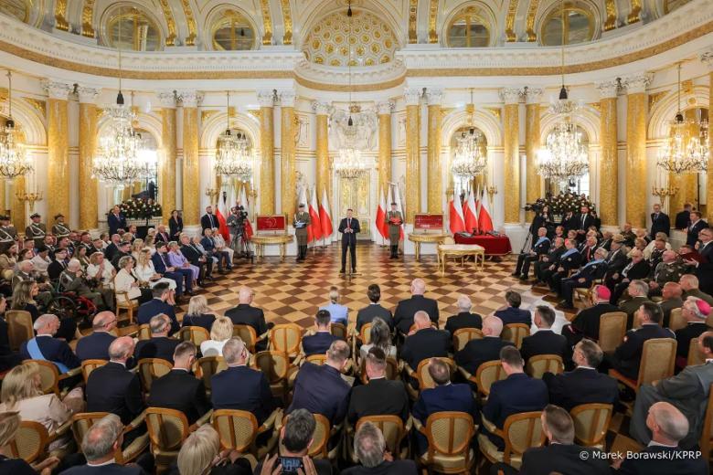 osoby siedzą w sali jedna przemawia