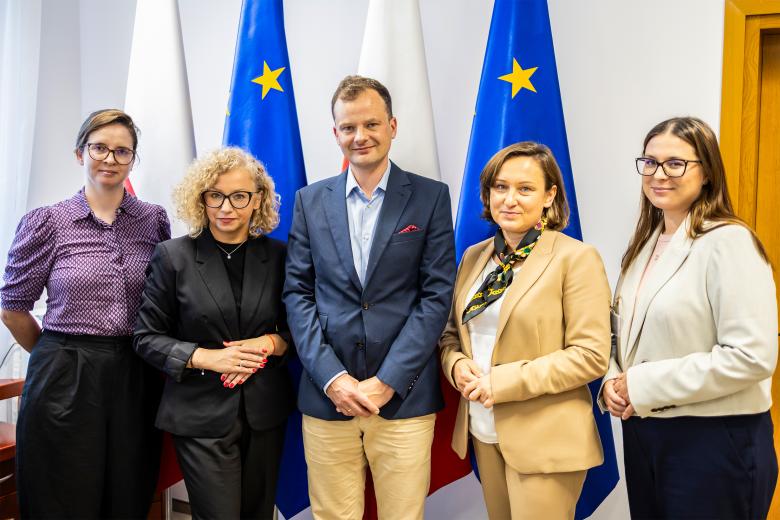 Pięć osób pozuje na stojąco do wspólnego zdjęcia