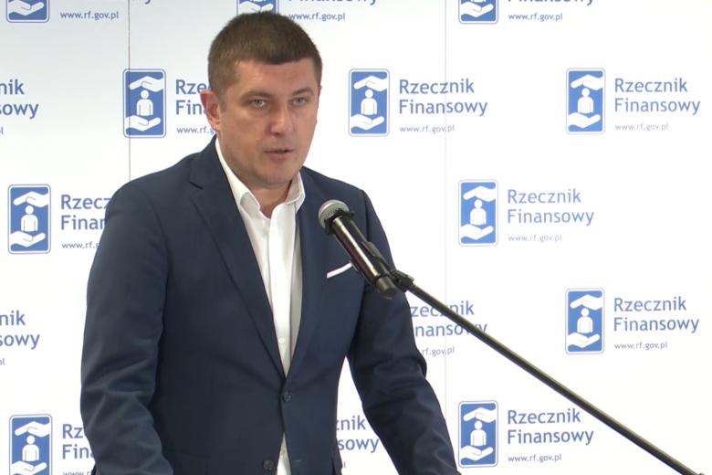 Wojciech Brzozowski stoi i wypowiada się do mikrofonu