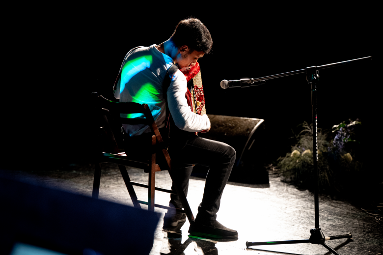 osoba gra na harmonii na siedząco 